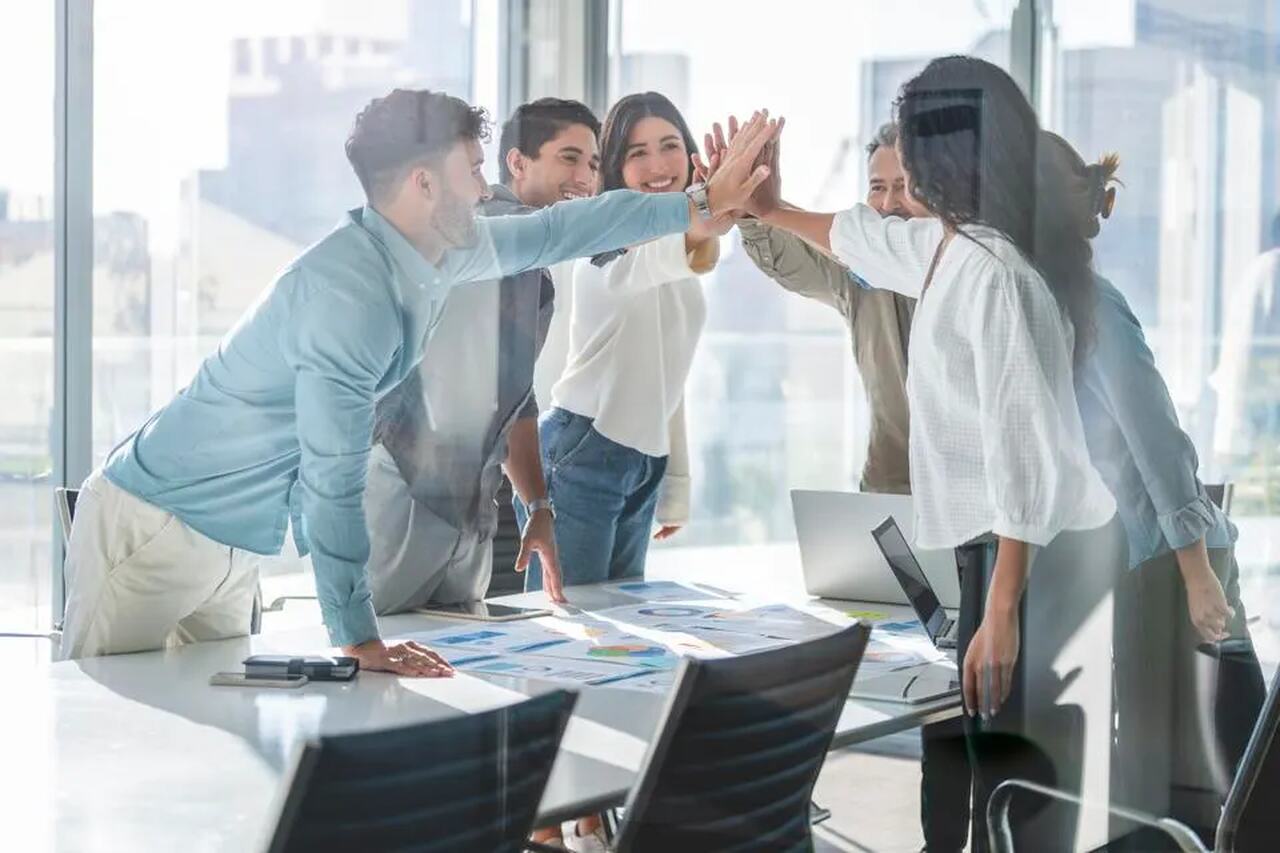 Pessoas sobre uma mesa dando as mãos sorrindo pelos indicadores de RH