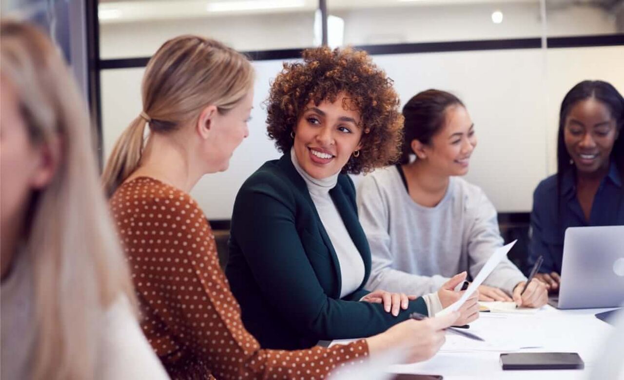 5 pessoas em uma mesa discutindo técnicas de recrutamento e seleção