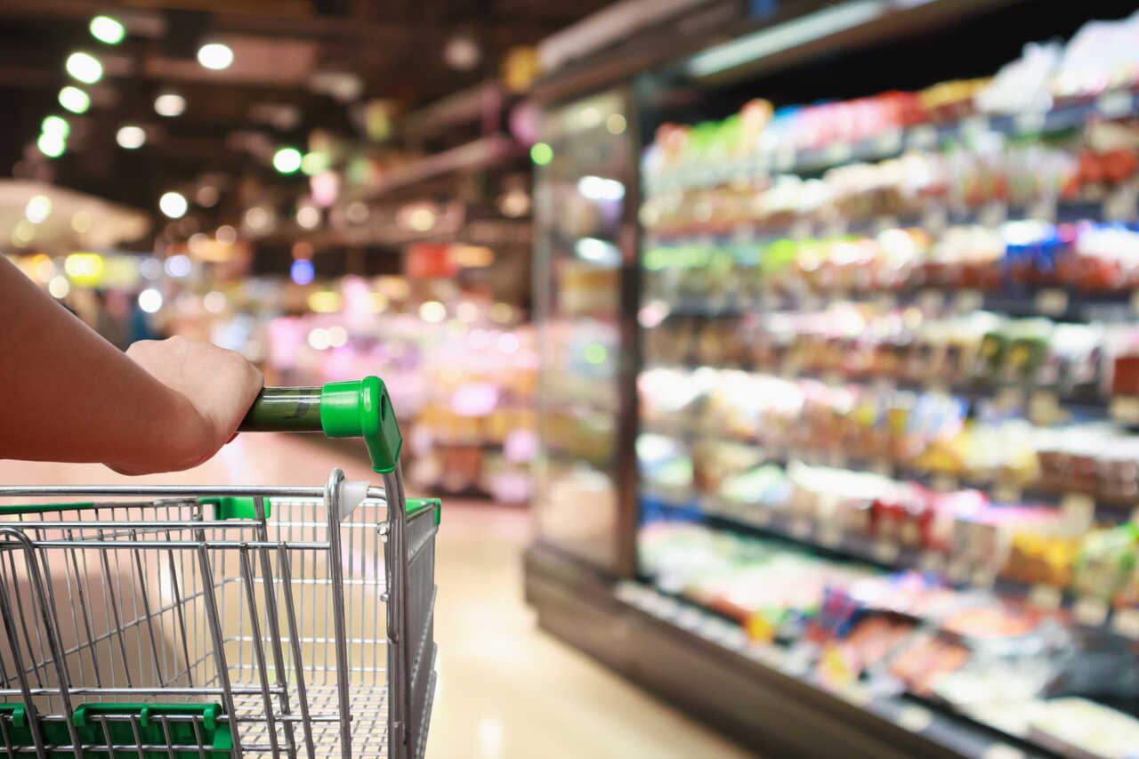 Pessoa com carrinho de rodas fazendo compras no mercado com o vale-alimentação