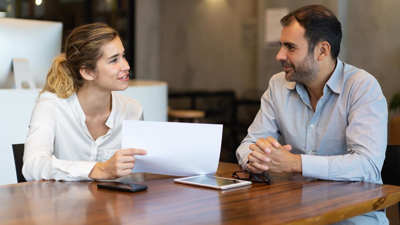 Homem e mulher conversando em uma entrevista de desligamento